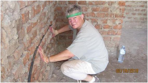 Lynne working on a brick wall